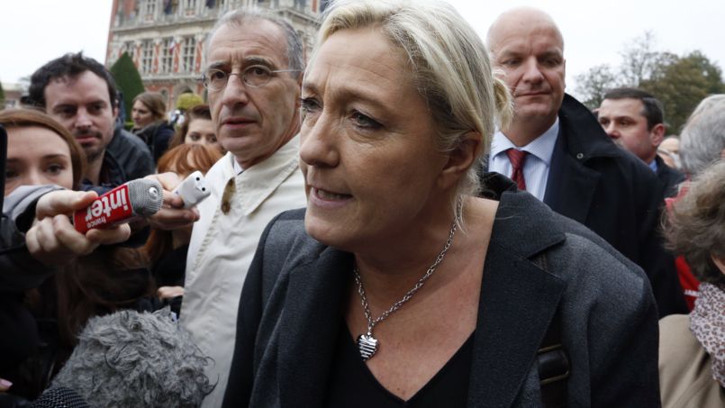 Marine Le Pen , France's National Front political party head, speaks to journalists as she walks near the town hall in Calais